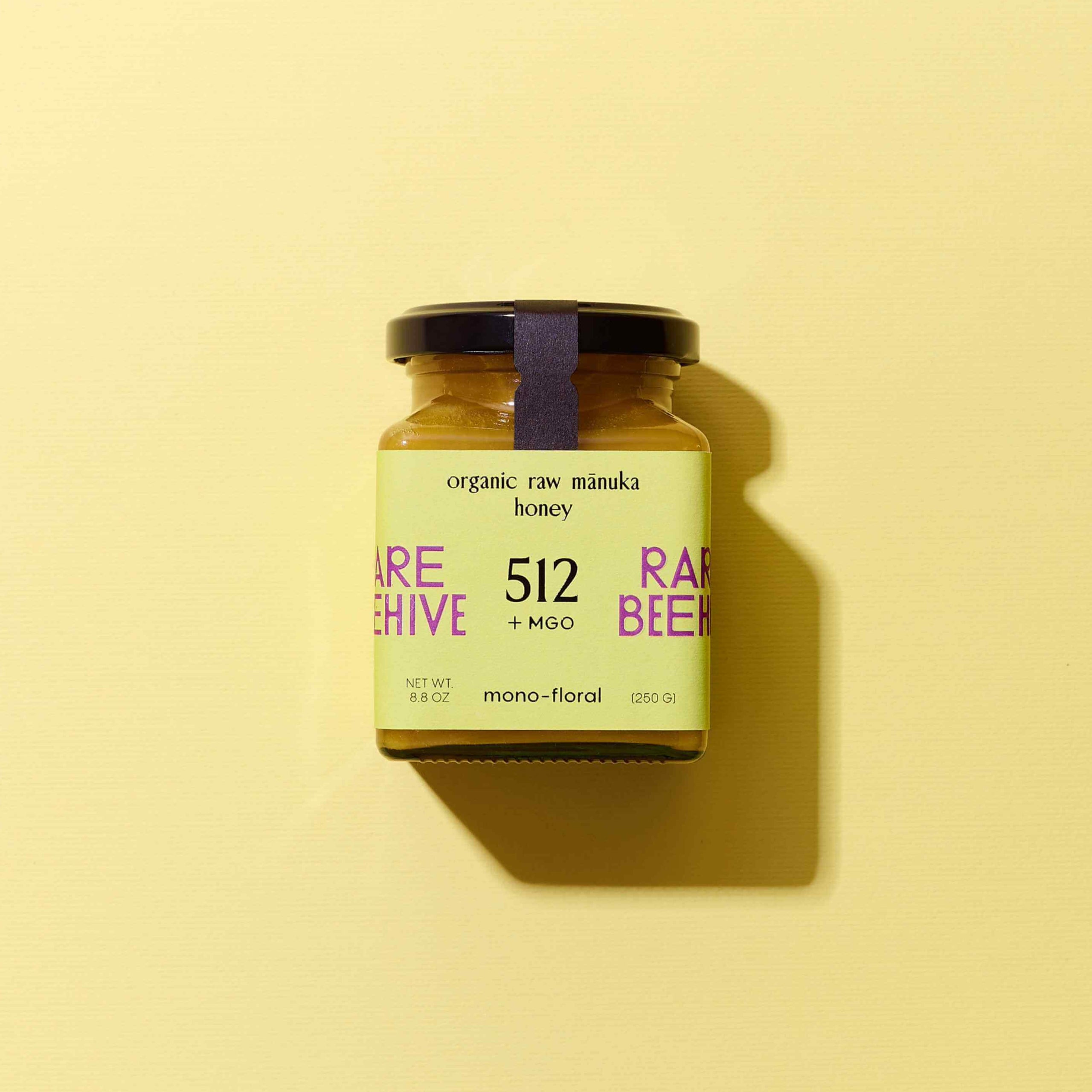 Jar of 512+ MGO Mānuka honey with a green label on a yellow background